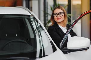 auto negocio, coche venta, consumismo y personas concepto - contento mujer tomando coche llave desde comerciante en auto espectáculo o salón. foto