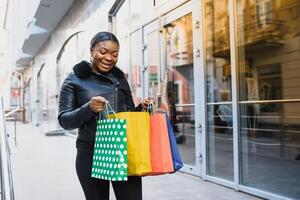 A shopping black woman carrying shopping bags outdoor photo