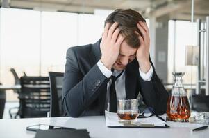 Young businessman drinking from stress photo