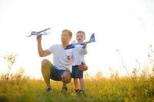 del padre día. papá y bebé hijo jugando juntos al aire libre avión foto