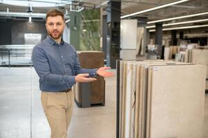 Portrait of a ceramic tile seller. The seller stands against the background of a large assortment of tiles photo