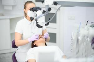 profesional dentista examen paciente con microscopio a el oficina foto