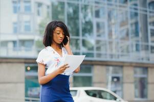 A pretty African american business woman talking on a cell phone at office building photo