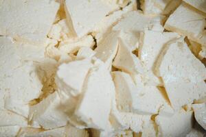 Assorted flavours of cheese wheels maturing on rows of wooden shelves in a cheese factory photo