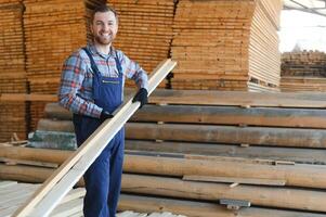 Timber harvesting for construction. Carpenter stacks boards. Industrial background. Authentic workflow. photo