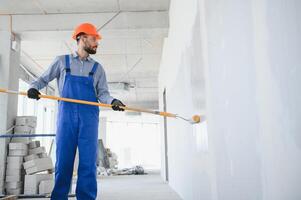 painter man painting the wall, with paint roller photo