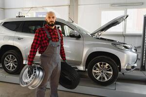 Mechanic holding a tire tire at the repair garage. replacement of winter and summer tires. photo