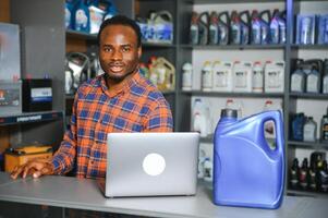 Portrait of a handsome african salesman in an auto parts store. The concept of car repair photo