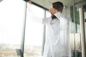 retrato de agotado cansado joven árabe masculino médico después difícil día a trabajo foto