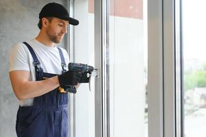 Construction worker installing window in house photo