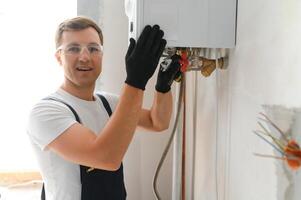 Gas engineer checking and cleaning a boiler during the inspection at home photo