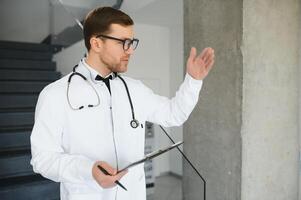 Male Doctor stands in the hall of the hospital photo
