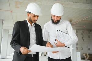 multiétnico negocio equipo. construcción concepto. indio y árabe ingenieros inspeccionar el construcción. foto