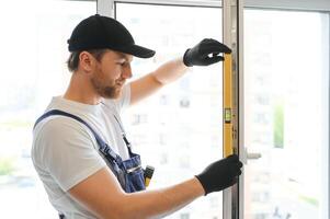 Construction worker repairing plastic window indoors, space for text. Banner design photo