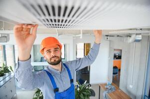 Happy Male Technician Repairing Air Conditioner. photo