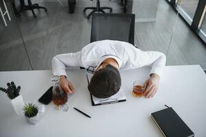 Young businessman drinking from stress photo