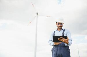 India ingeniero a molino granja operación a generar electricidad, asiático hombre trabajando a viento turbina granja, limpiar y verde energía. foto