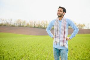 worry less ,indian farmer standing in his healthy wheat field photo