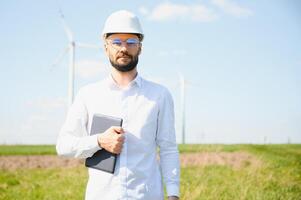 Engineer in field checking on turbine production photo