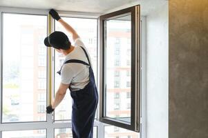 Servicio hombre instalando ventana con medida cinta foto