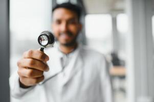Indian doctor holding stethoscope at clinics photo