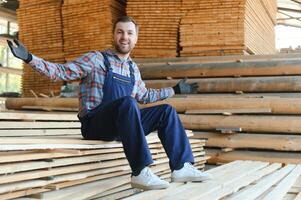 Timber harvesting for construction. Carpenter stacks boards. Industrial background. Authentic workflow. photo