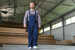 Young man carpenter at the wooden warehouse. Copy space for text photo