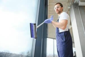 An employee of a professional cleaning service washes the glass of the windows of the building. Showcase cleaning for shops and businesses. photo