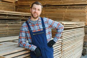 Male Worker folds boards. Sawmill. Wood harvesting process photo