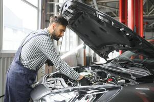 Professional Mechanic is Working on a Car in a Car Service. photo