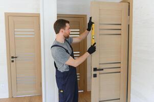 Young man fixing the door in house photo