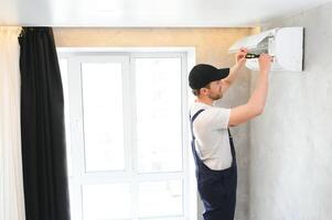 Service man is cleaning, repair and maintenance of air conditioner. photo