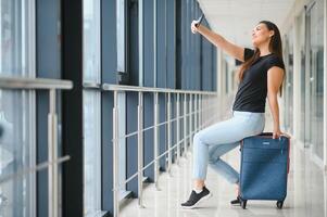 bonito mujer esperando para su vuelo a aeropuerto foto