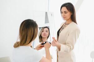 retrato de un hermosa mujer, su labios son pintado con rosado lápiz labial, mirando en el espejo. foto