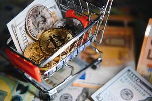 Close up heap of golden bitcoin physical coins on top of Euro, dollar banknotes background, high angle view, selective focus photo