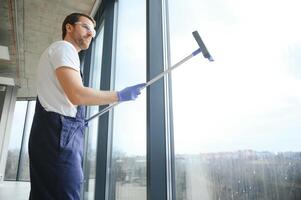 Male worker washing window glass photo