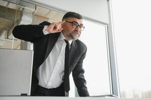 Angry businessman sitting at the table and screaming over. photo