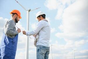 dos asiático ingenieros masculino comprobación viento turbinas renovable energía tecnología y sostenibilidad. alternativa energía para futuro. foto