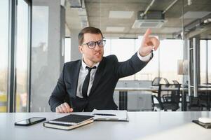 Angry businessman sitting at his desk and screaming at his employees. photo