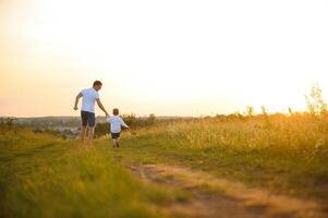 Father's day. Happy family father and toddler son playing and laughing on nature at sunset photo