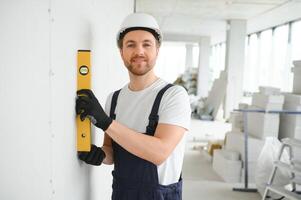Professional Workman Applying Silicone Sealant With Caulking Gun on the Wall photo