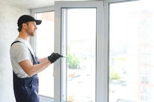 Construction worker installing window in house photo