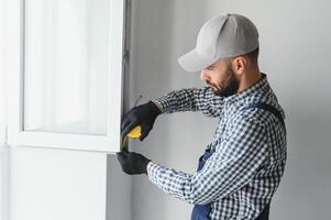 Construction worker installing window in house photo