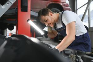 Portrait of a smiling fixing a car engine in his garage photo