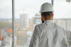 Young attractive arabic industrial engineer in hard hat. Professional and industry, builder architect job, worker checking work at plant indoor photo