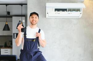 Servicio hombre es limpieza, reparar y mantenimiento de aire acondicionador. foto