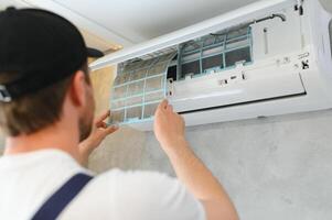 Service man is cleaning, repair and maintenance of air conditioner. photo