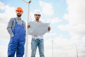 dos asiático ingenieros masculino comprobación viento turbinas renovable energía tecnología y sostenibilidad. alternativa energía para futuro. foto