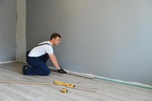 Man installing new laminated wooden floor photo