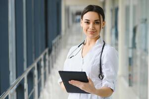 Woman doctor standing with folder at hospital. photo